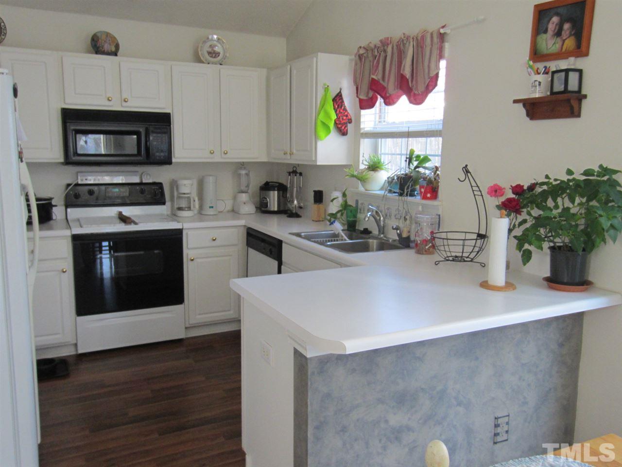 9901 Treymore Drive Raleigh, NC 27617 - Photo 25 of 25 a kitchen with stainless steel appliances a sink a stove a microwave a sink and cabinets