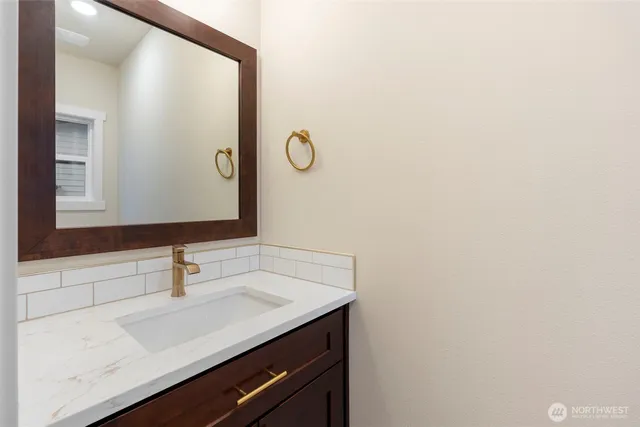a bathroom with a double vanity sink mirror and a bathtub