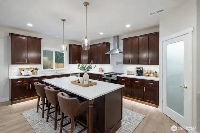 a kitchen with stainless steel appliances granite countertop a stove a sink and a microwave