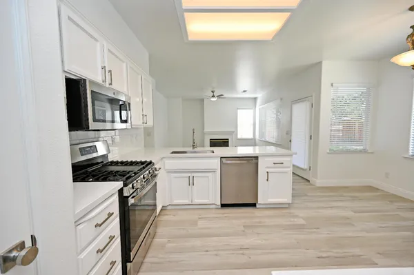 a kitchen with white cabinets and sink