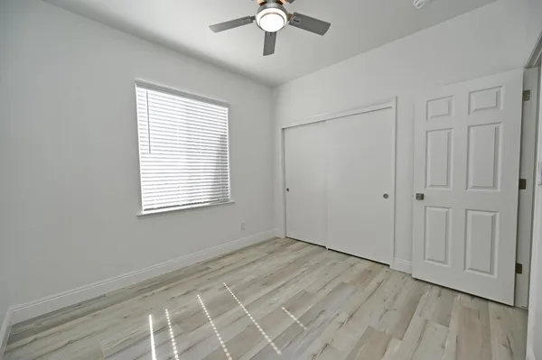 a bedroom with a large bed and a ceiling fan