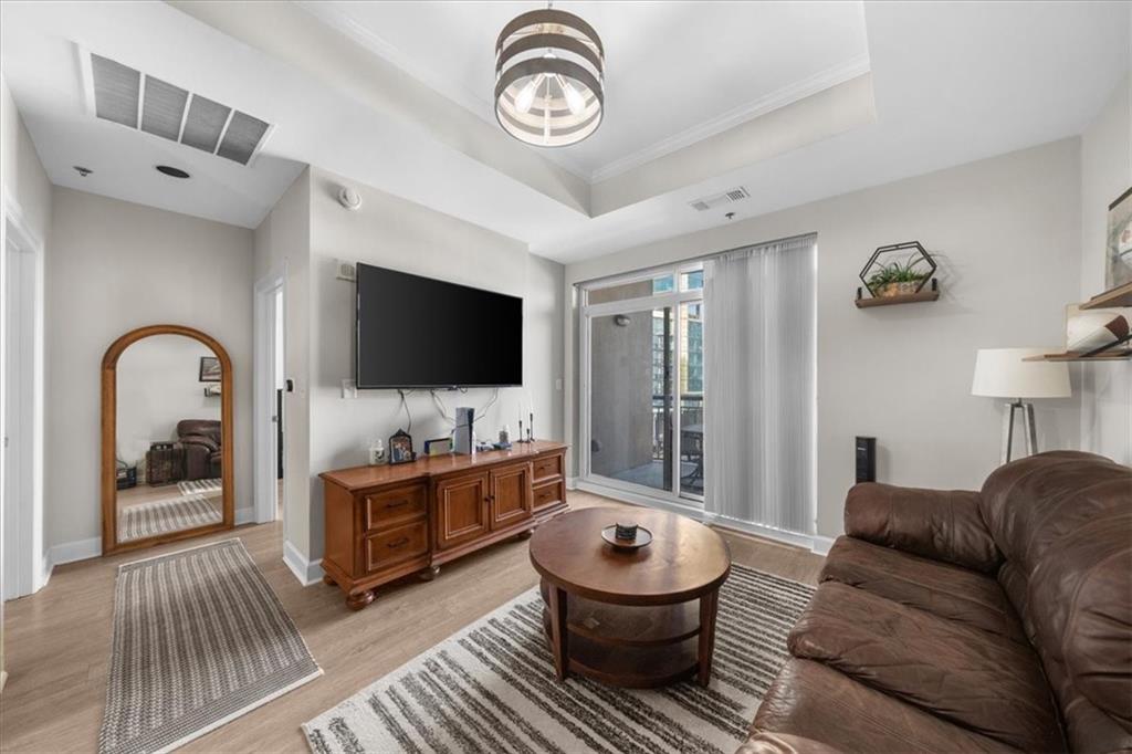 325 East Paces Ferry Road Northeast, Unit 504 Atlanta, GA 30305 - Photo 13 of 45 a living room with furniture a flat screen tv and a large window