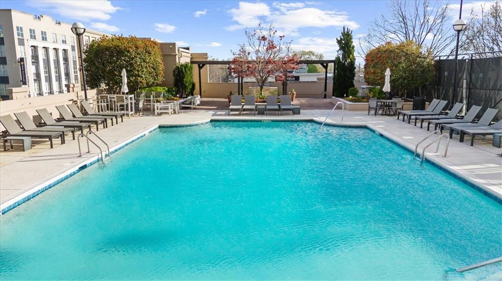 325 East Paces Ferry Road Northeast, Unit 504 Atlanta, GA 30305 - Photo 23 of 45 a view of a swimming pool with outdoor seating and plants