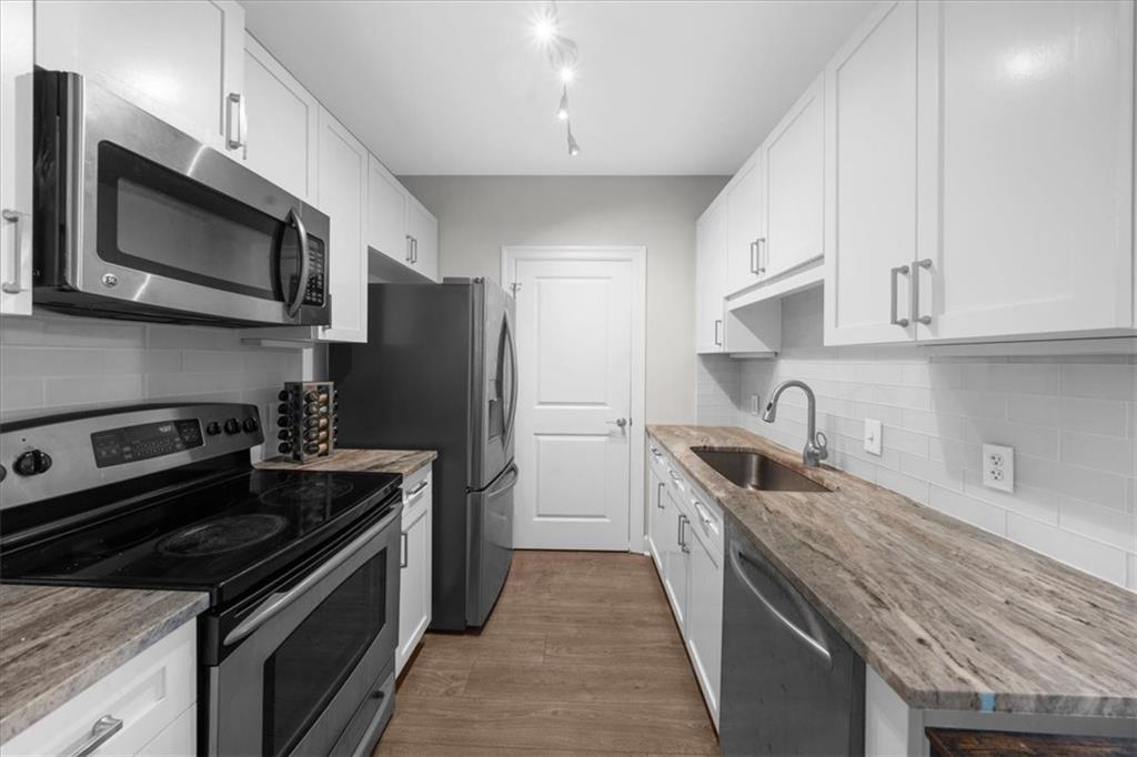 325 East Paces Ferry Road Northeast, Unit 504 Atlanta, GA 30305 - Photo 3 of 45 a kitchen with stainless steel appliances granite countertop a stove microwave and sink