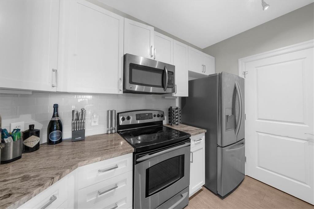 325 East Paces Ferry Road Northeast, Unit 504 Atlanta, GA 30305 - Photo 4 of 45 a kitchen with granite countertop a refrigerator stove and microwave