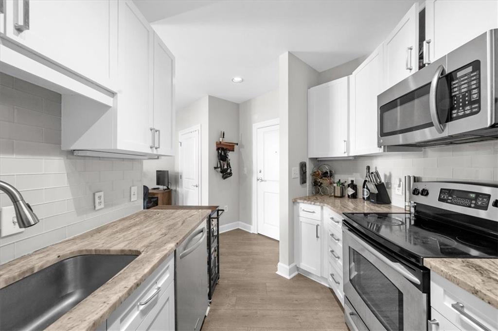 325 East Paces Ferry Road Northeast, Unit 504 Atlanta, GA 30305 - Photo 6 of 45 a kitchen with stainless steel appliances granite countertop a sink stove and microwave