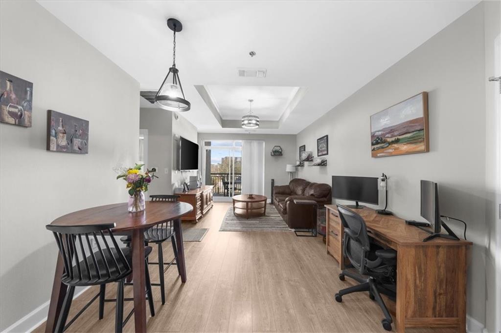 325 East Paces Ferry Road Northeast, Unit 504 Atlanta, GA 30305 - Photo 8 of 45 a view of a livingroom and a dining room with furniture wooden floor and a chandelier