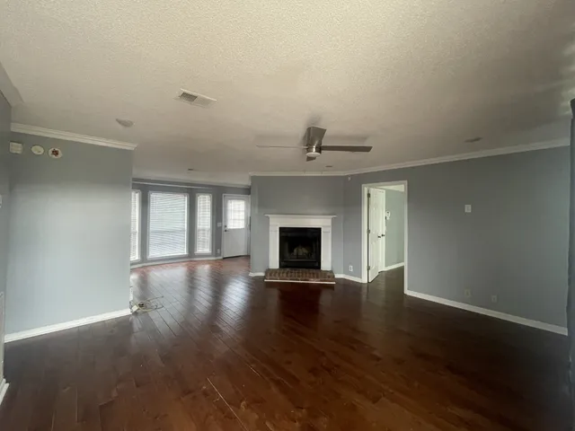an empty room with wooden floor and fireplace