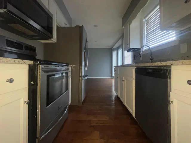 a kitchen with stainless steel appliances granite countertop a refrigerator and a stove