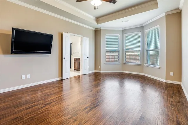 a view of a livingroom with wooden floor and a ceiling fan
