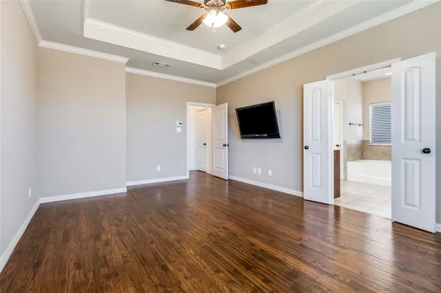 a view of a livingroom with wooden floor and a ceiling fan