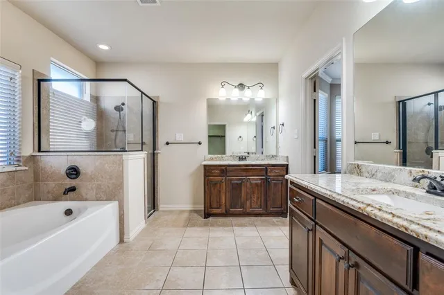 a bathroom with a tub a sink and mirror