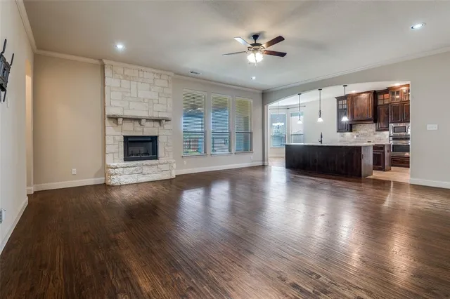 an empty room with fireplace wooden floor and windows