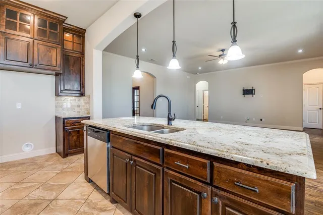 a kitchen with a sink and a stove with wooden floor
