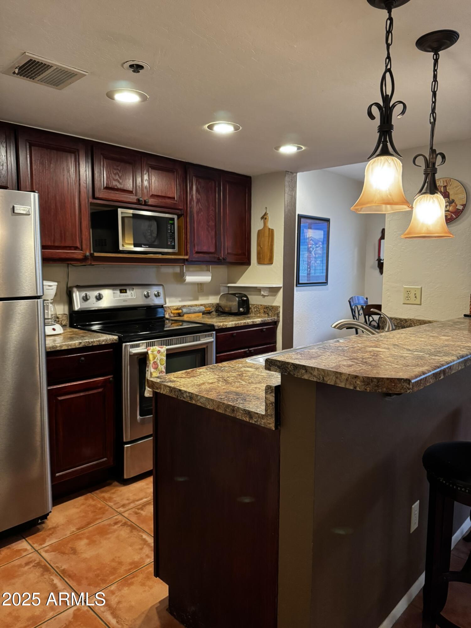12123 West Bell Road, Unit 337 Surprise, AZ 85378 - Photo 24 of 50 a kitchen with kitchen island granite countertop stainless steel appliances and a sink