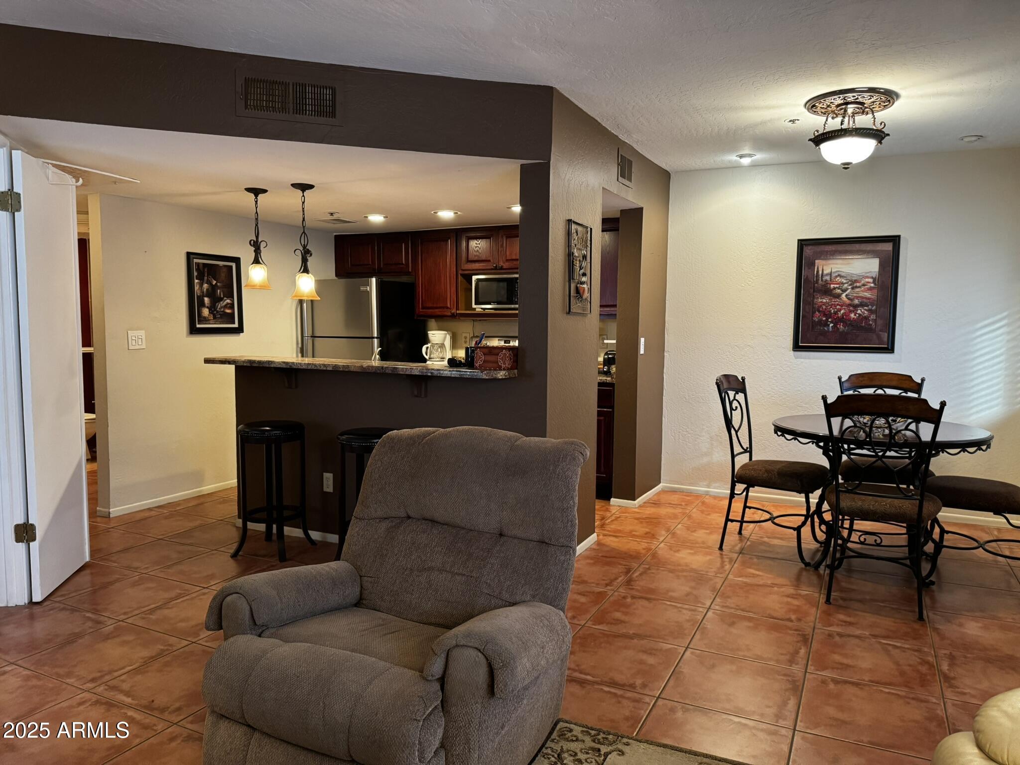 12123 West Bell Road, Unit 337 Surprise, AZ 85378 - Photo 4 of 50 a living room with furniture and kitchen view