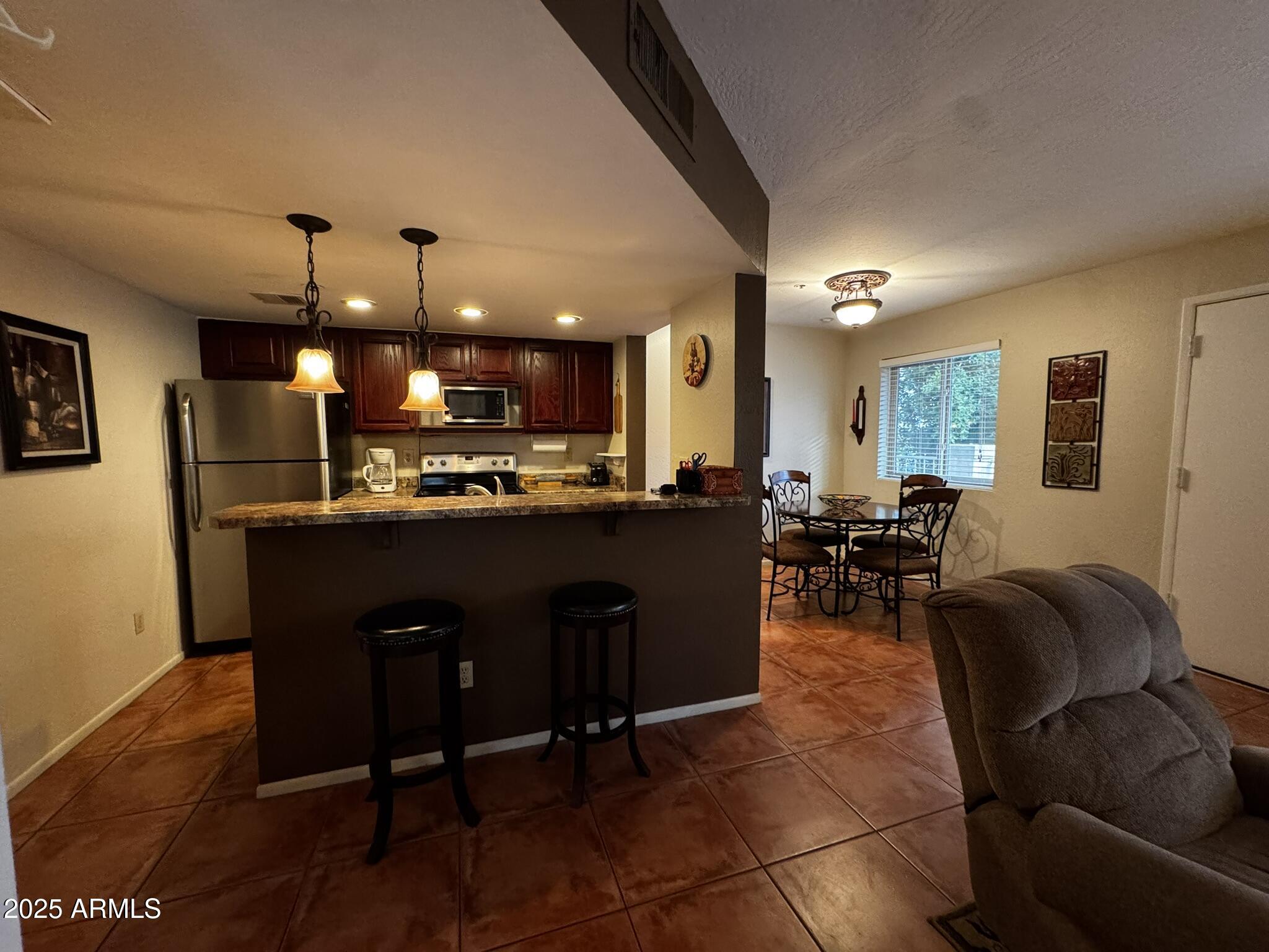 12123 West Bell Road, Unit 337 Surprise, AZ 85378 - Photo 5 of 50 a living room with stainless steel appliances kitchen island granite countertop furniture a rug and a view of kitchen