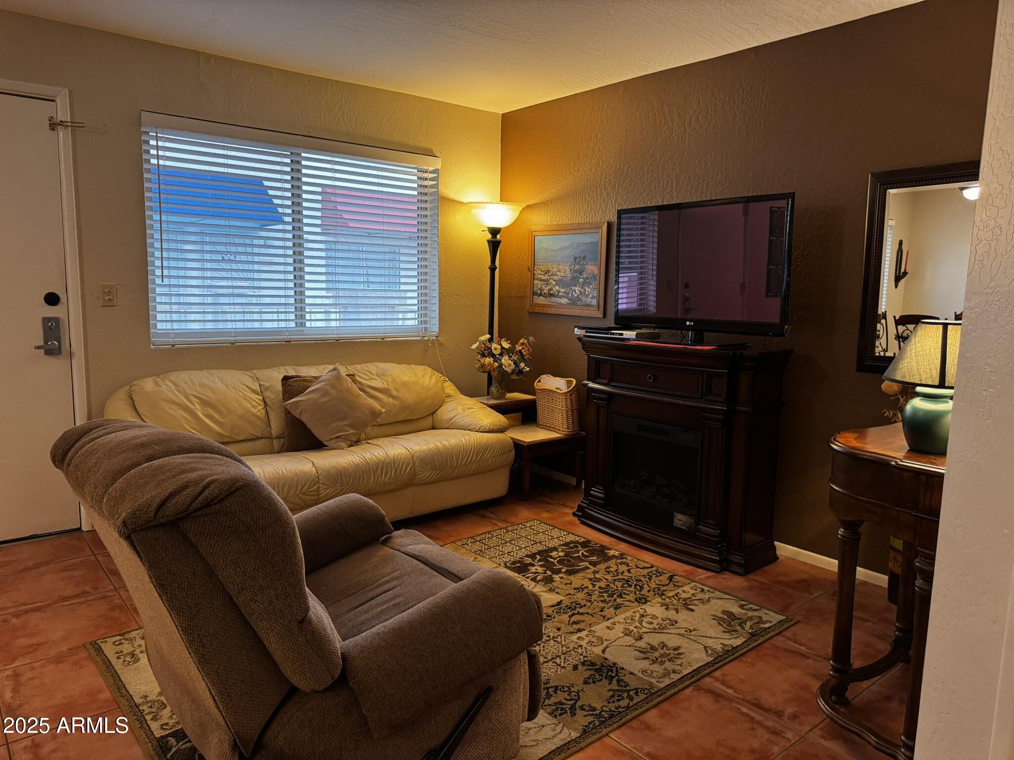 12123 West Bell Road, Unit 337 Surprise, AZ 85378 - Photo 8 of 50 a living room with furniture a lamp and a flat screen tv