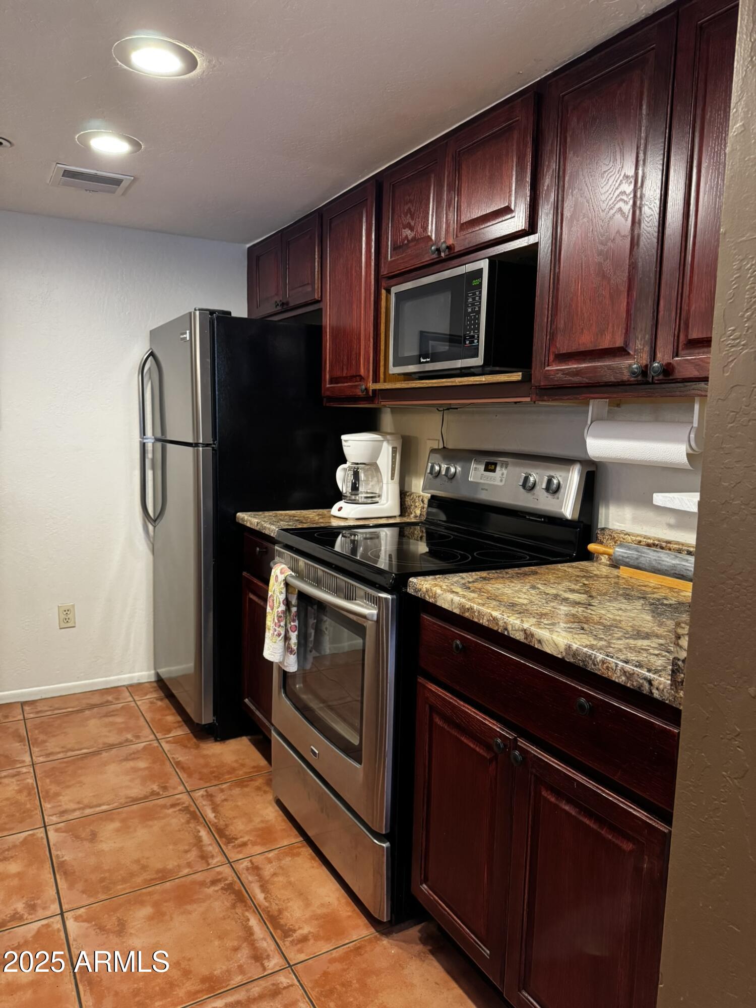 12123 West Bell Road, Unit 337 Surprise, AZ 85378 - Photo 10 of 50 a kitchen with granite countertop stainless steel appliances and wooden cabinets