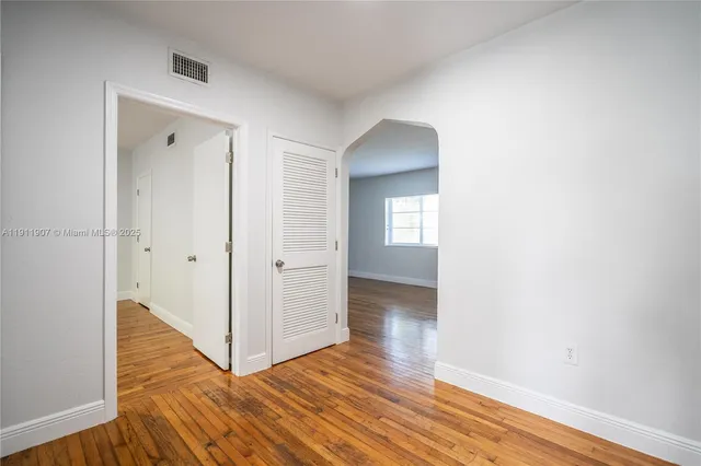 a view of a hallway with wooden floor and closet