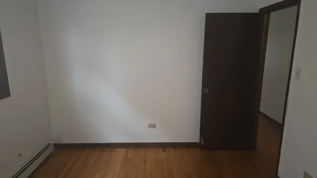 an empty room with wooden floor and sliding door