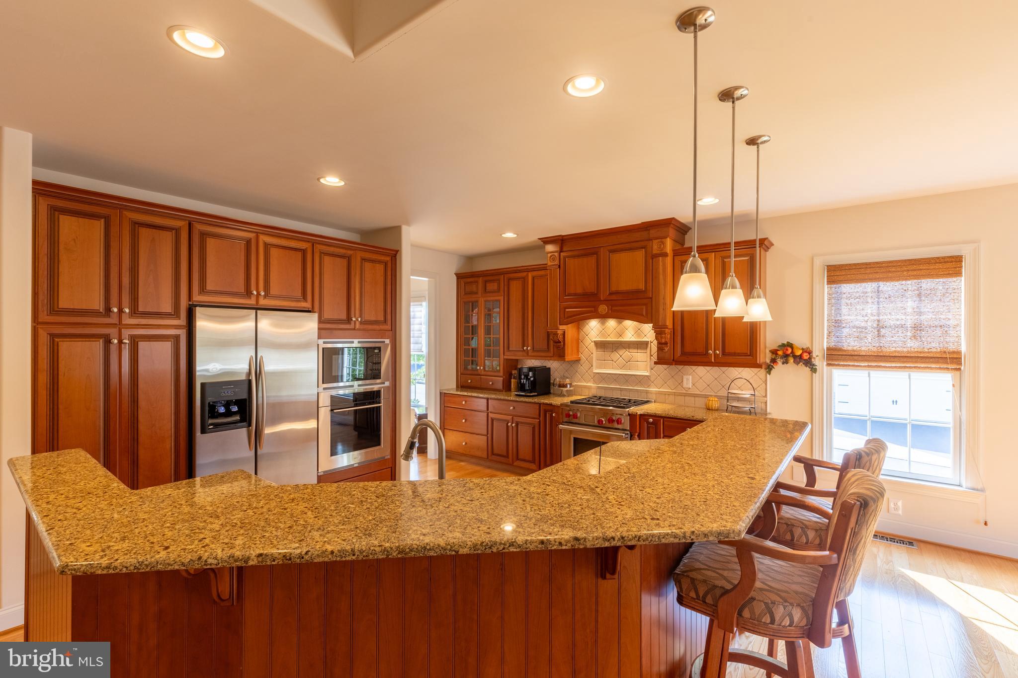 101 Cornwall Road, Unit 116 Landenberg, PA 19350 - Photo 8 of 30 a kitchen with stainless steel appliances granite countertop dining table chairs and wooden cabinets