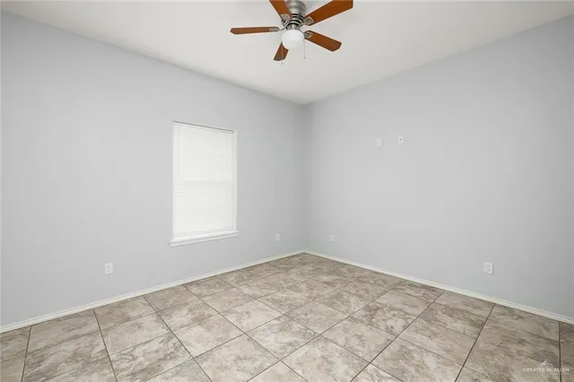 an empty room with a window and a ceiling fan