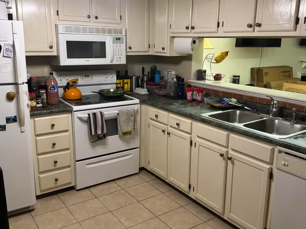 a kitchen with white cabinets and white appliances