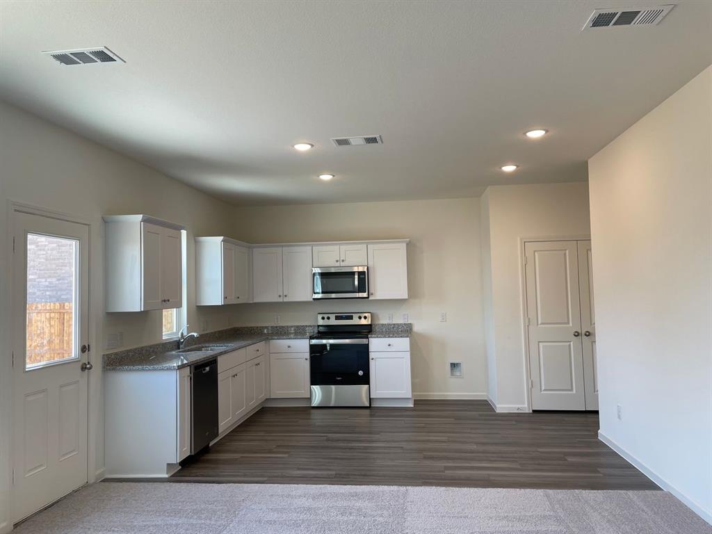1911 Chapel Hill Road Princeton, TX 75407 - Photo 2 of 14 a kitchen with granite countertop a stove top oven and cabinets