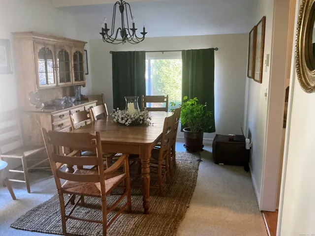 a view of a dining room with furniture a chandelier and wooden floor