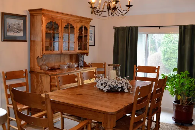 a living room with furniture a chandelier and a large window