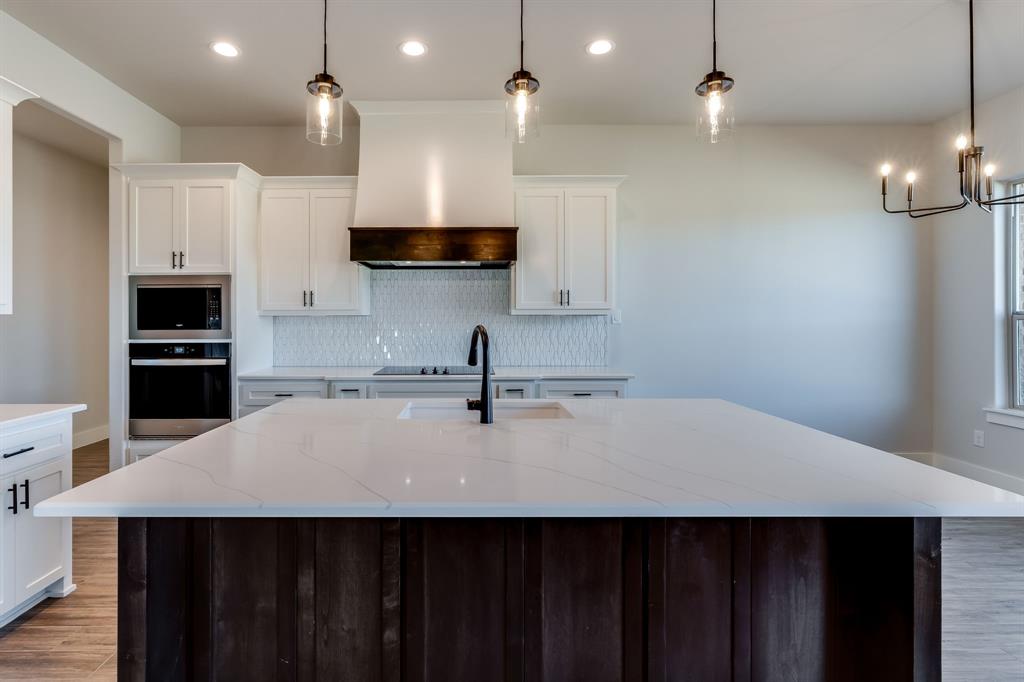7017 Rnch Vw Place Springtown, TX 76082 - Photo 11 of 38 a kitchen with kitchen island a sink stainless steel appliances and cabinets