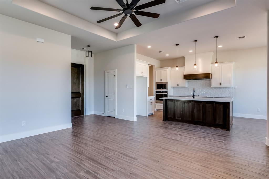 7017 Rnch Vw Place Springtown, TX 76082 - Photo 6 of 38 a large kitchen with stainless steel appliances kitchen island granite countertop a large counter top and sink