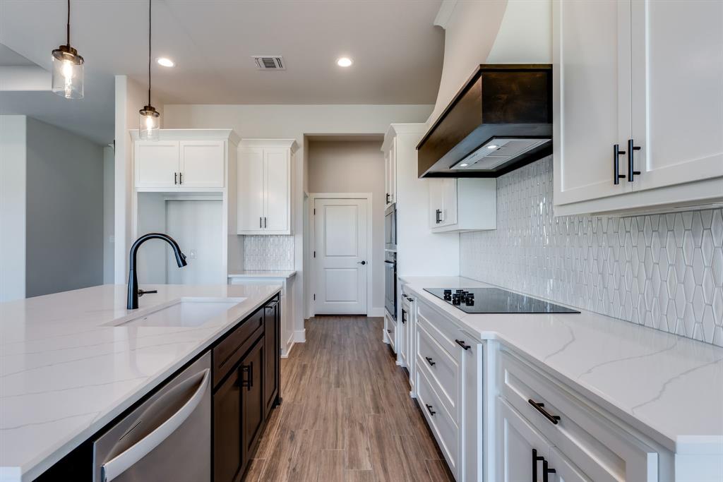 7017 Rnch Vw Place Springtown, TX 76082 - Photo 8 of 38 a kitchen with kitchen island stainless steel appliances a sink a stove and cabinets