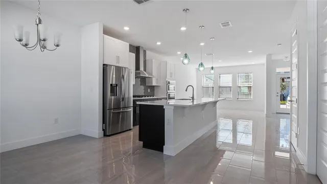 a kitchen with kitchen island white cabinets and refrigerator