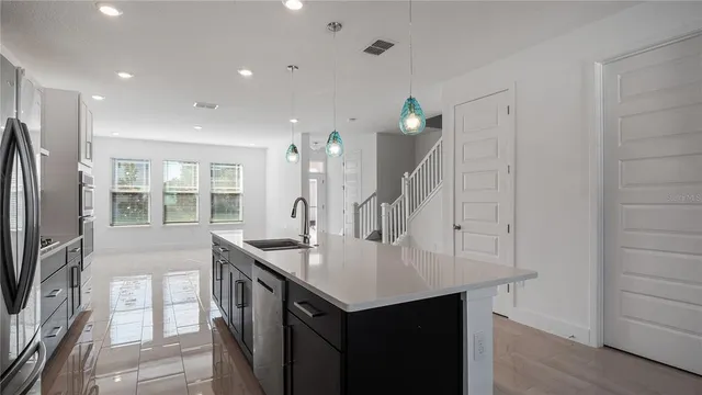 a kitchen with stainless steel appliances granite countertop a sink a stove and a refrigerator