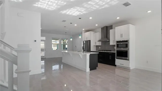 a large white kitchen with lots of counter space a sink and appliances
