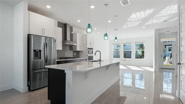 a kitchen with stainless steel appliances granite countertop a refrigerator and a sink
