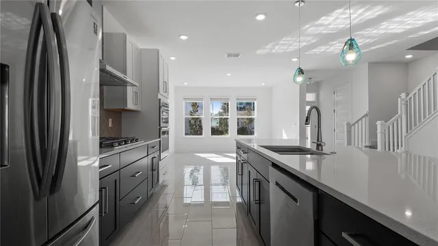 a kitchen with stainless steel appliances granite countertop a sink a stove and a refrigerator