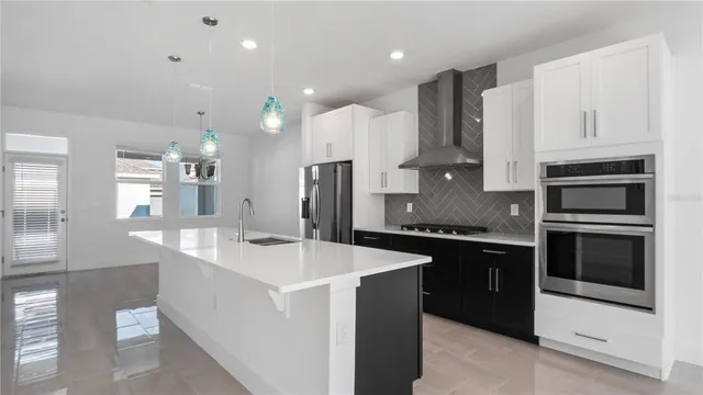 a kitchen with stainless steel appliances kitchen island a sink stove and refrigerator