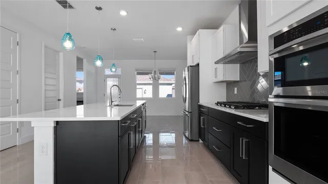 a kitchen with granite countertop a sink a counter top space stainless steel appliances and cabinets