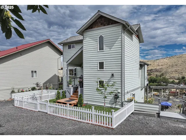 a view of a house with a small yard and wooden fence