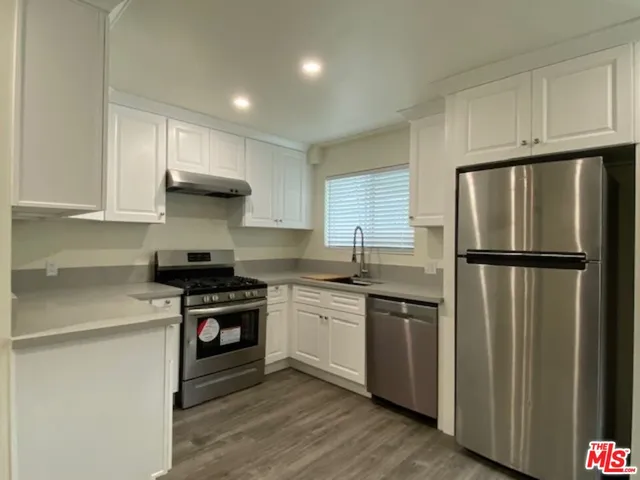 a kitchen with stainless steel appliances granite countertop a stove a refrigerator and a sink