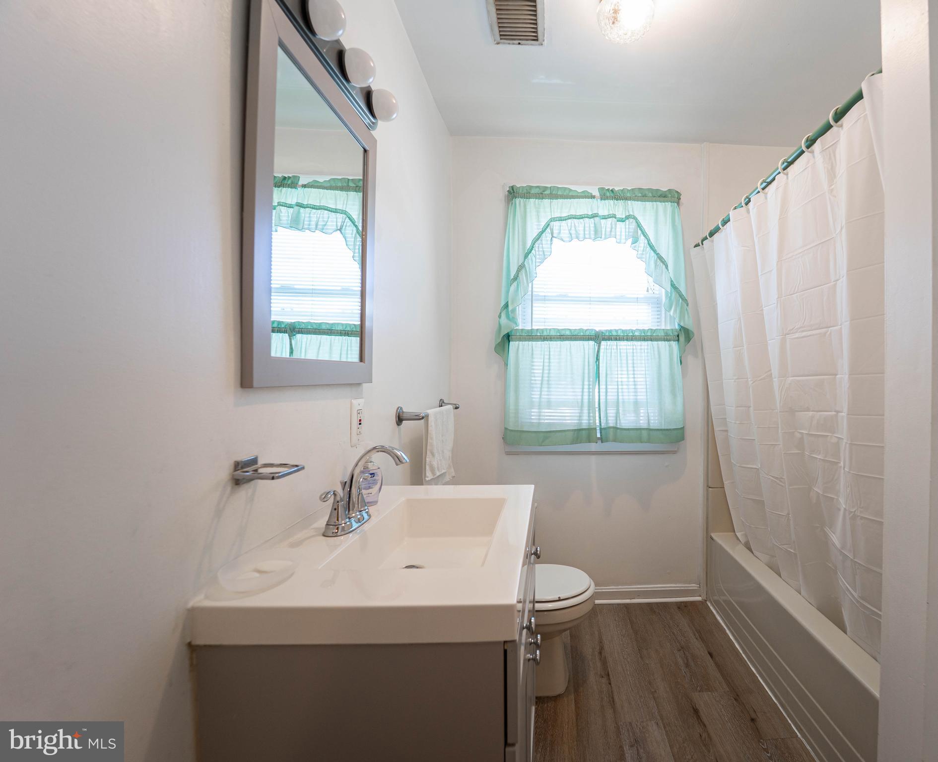6515 Frederick Road Catonsville, MD 21228 - Photo 11 of 30 a bathroom with a sink a mirror and a window