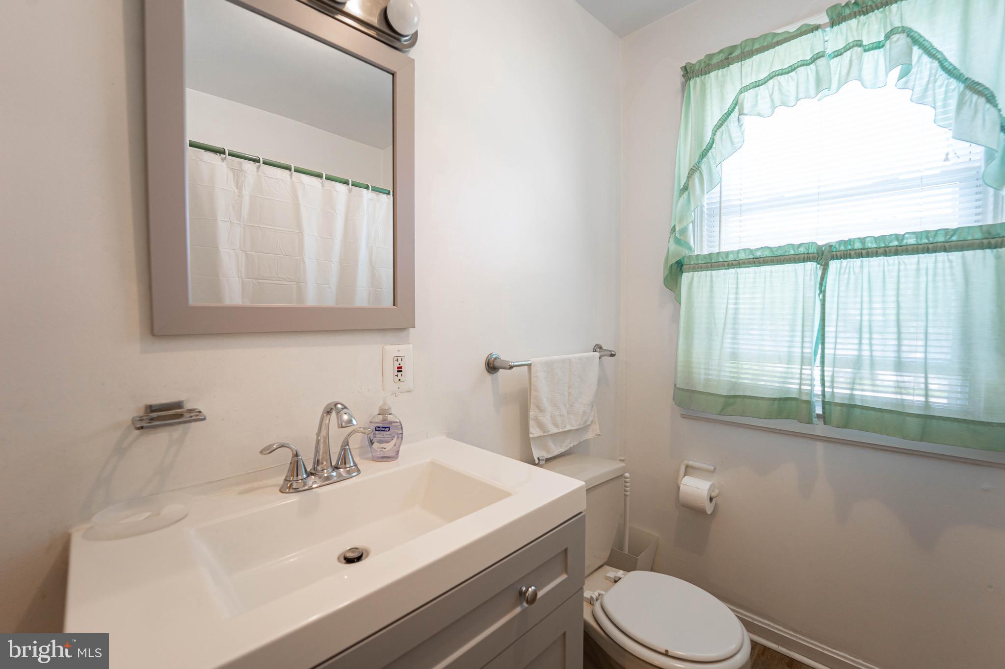 6515 Frederick Road Catonsville, MD 21228 - Photo 12 of 30 a bathroom with a sink a toilet and a mirror