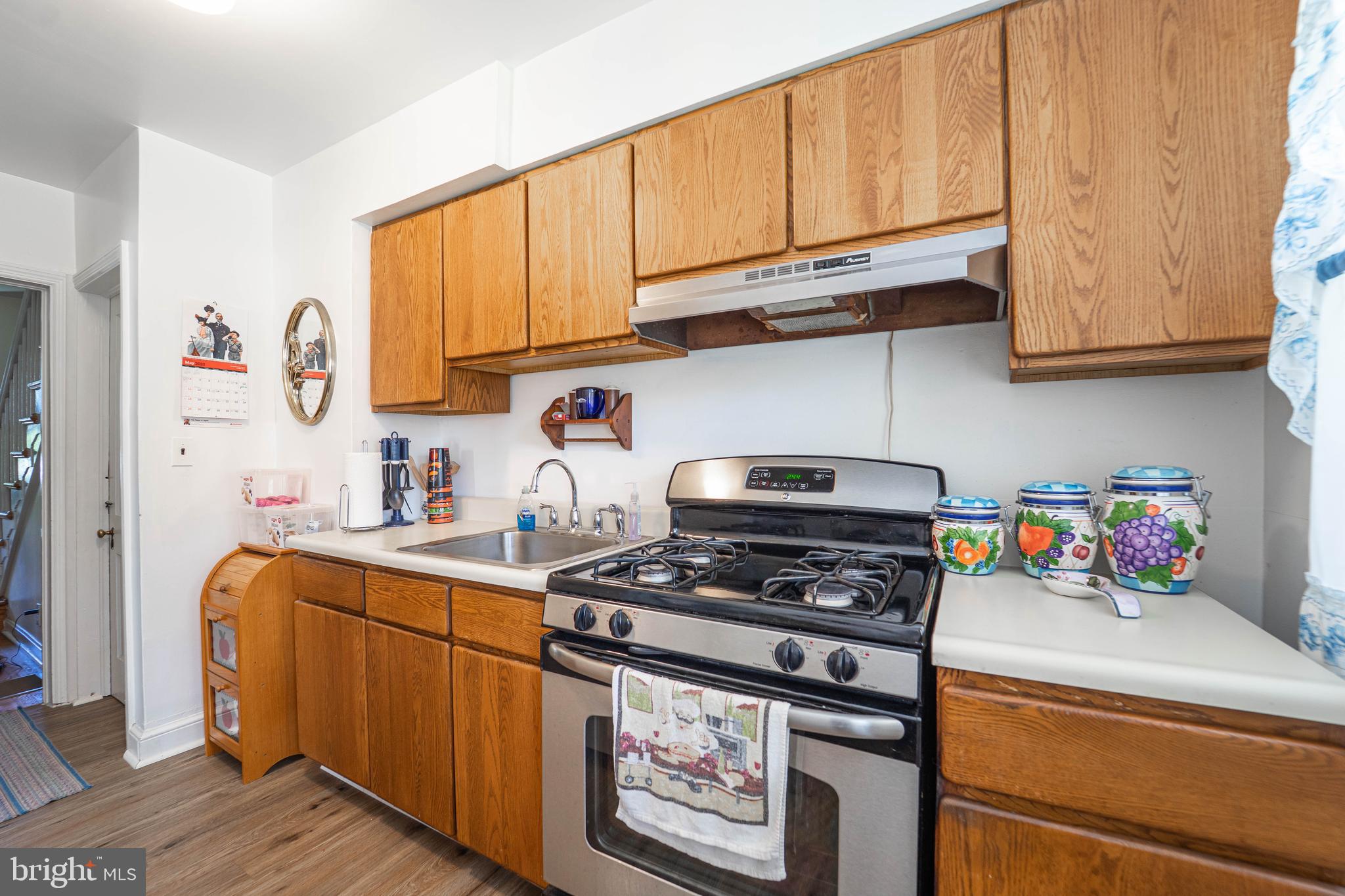 6515 Frederick Road Catonsville, MD 21228 - Photo 20 of 30 a kitchen with stainless steel appliances granite countertop a stove a sink and cabinets