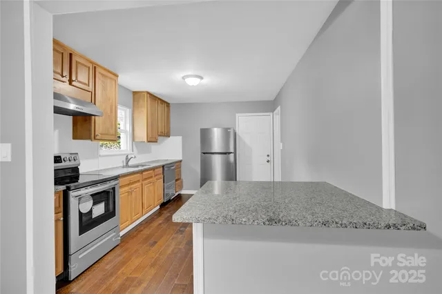 a large kitchen with cabinets stainless steel appliances and a counter space