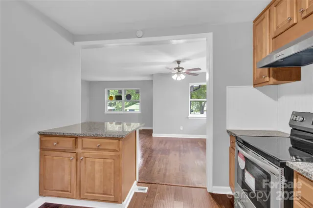 a view of a kitchen with furniture and wooden floor