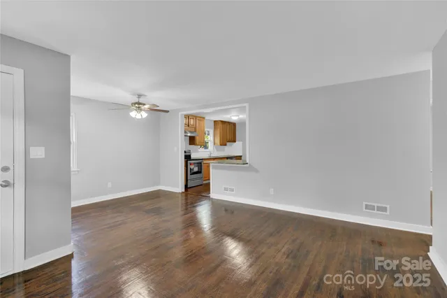 a view of a kitchen with wooden floor and a ceiling fan
