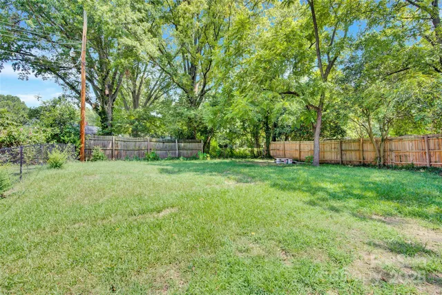 a view of yard with green space and trees